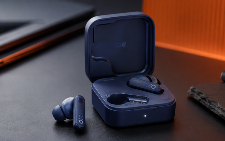 CMF Buds Neo wireless earbuds with charging case in dark blue finish on a modern studio desk