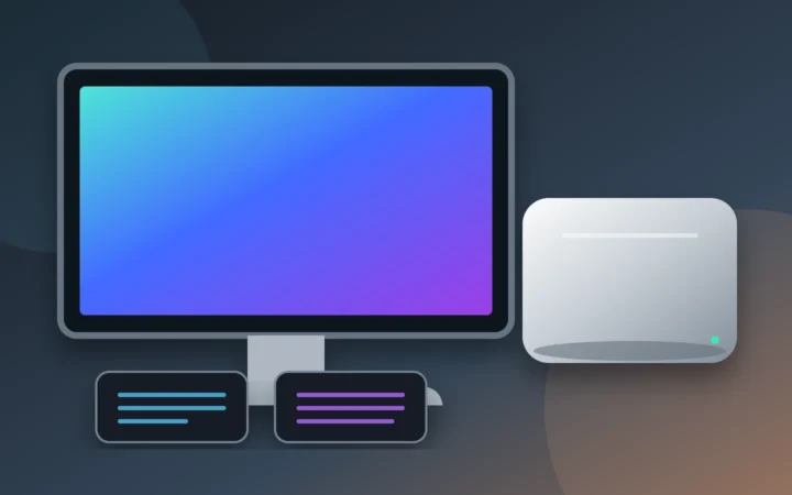 Compact silver desktop computer with two storage modules, monitor and keyboard on a clean desk
