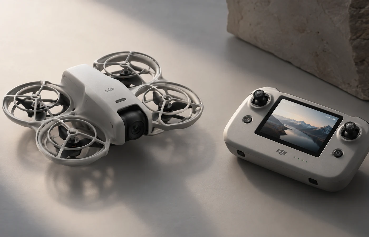 Compact drone controller with built-in display beside a guarded mini drone