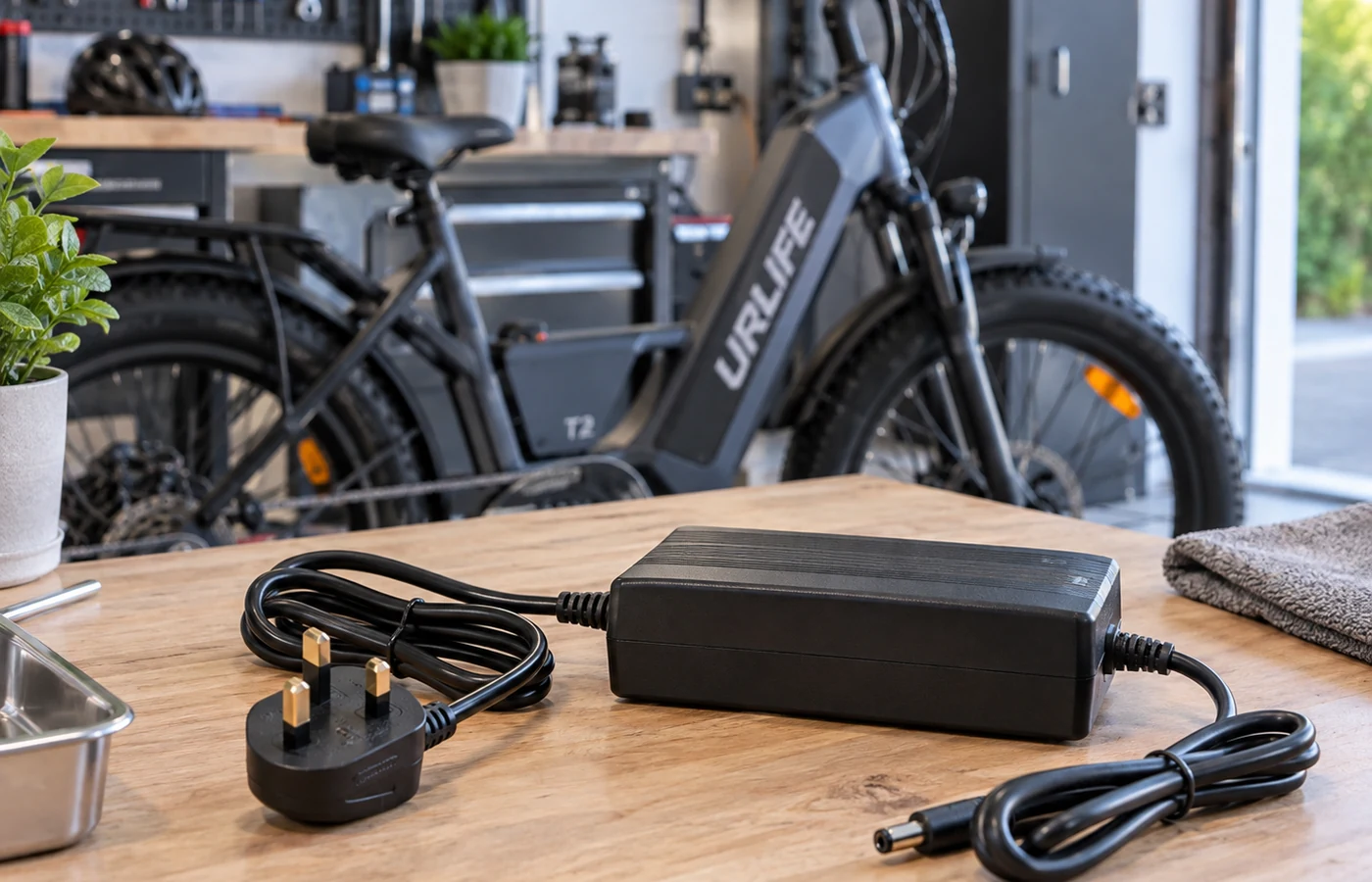 E-bike charger and UK plug beside a URLIFE T2 electric bike